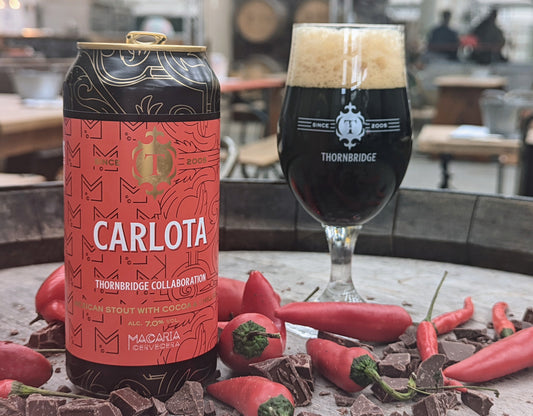 Carlota mexican chocolate chilli stout, can and poured into the glass on a bed of red chillis
