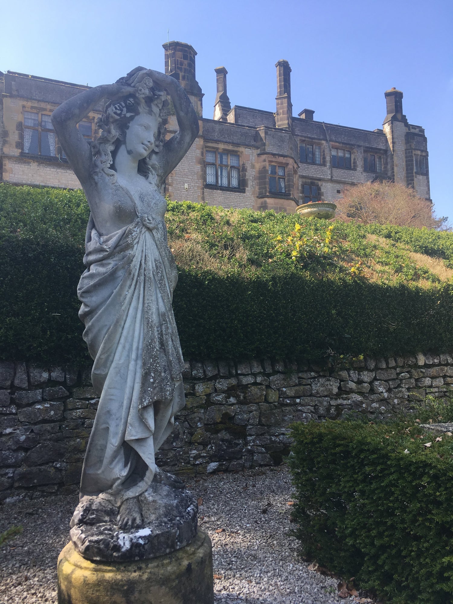 Image of Flora statue in the grounds of Thornbridge hall with the Hall in the background