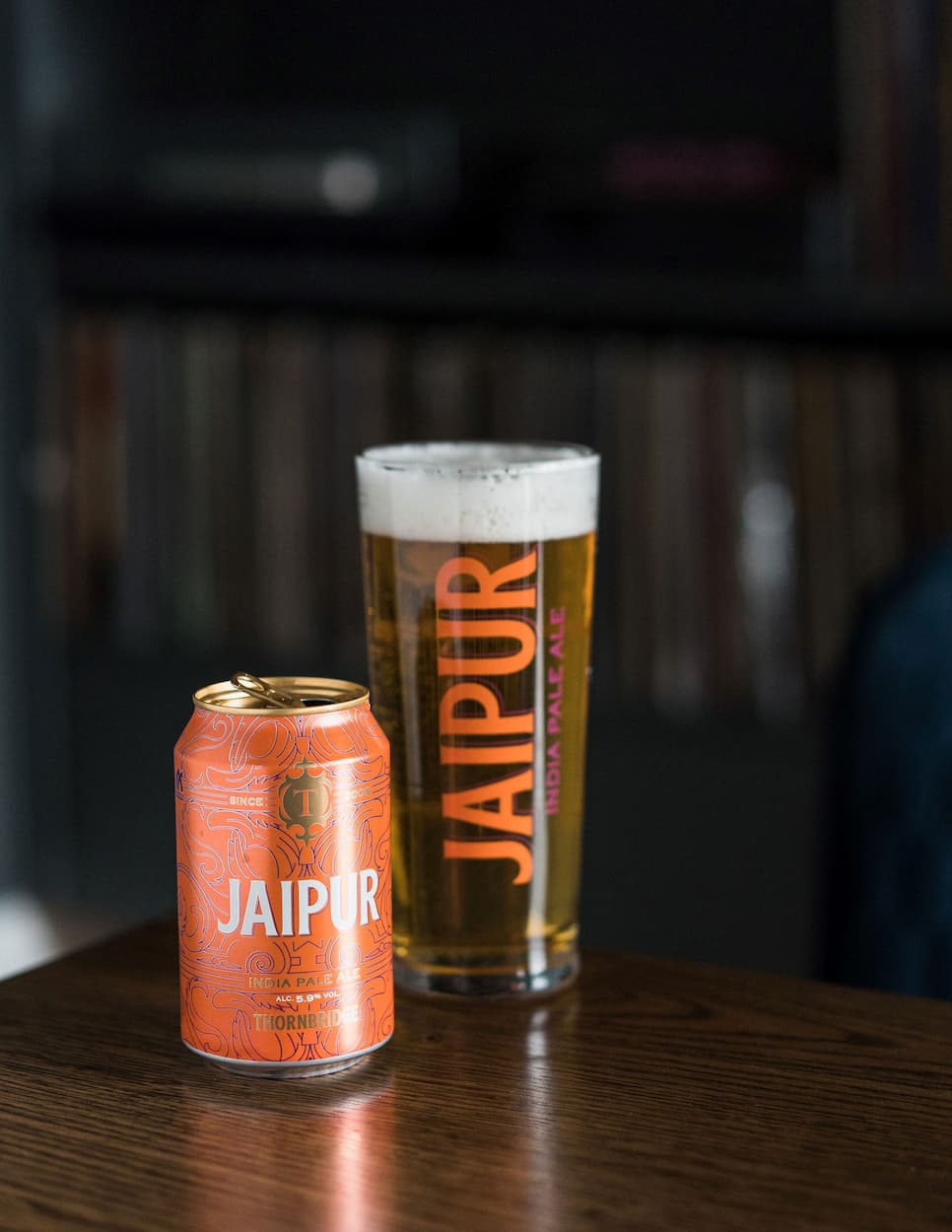 A full jaipur pint glass next to a can of Jaipur taken inside the inside the Bankers Cat pub