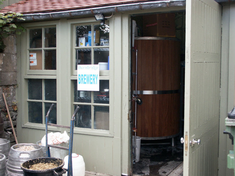Thornbridge Brewery building with a large wooden tank and 'BREWERY' sign on a window.